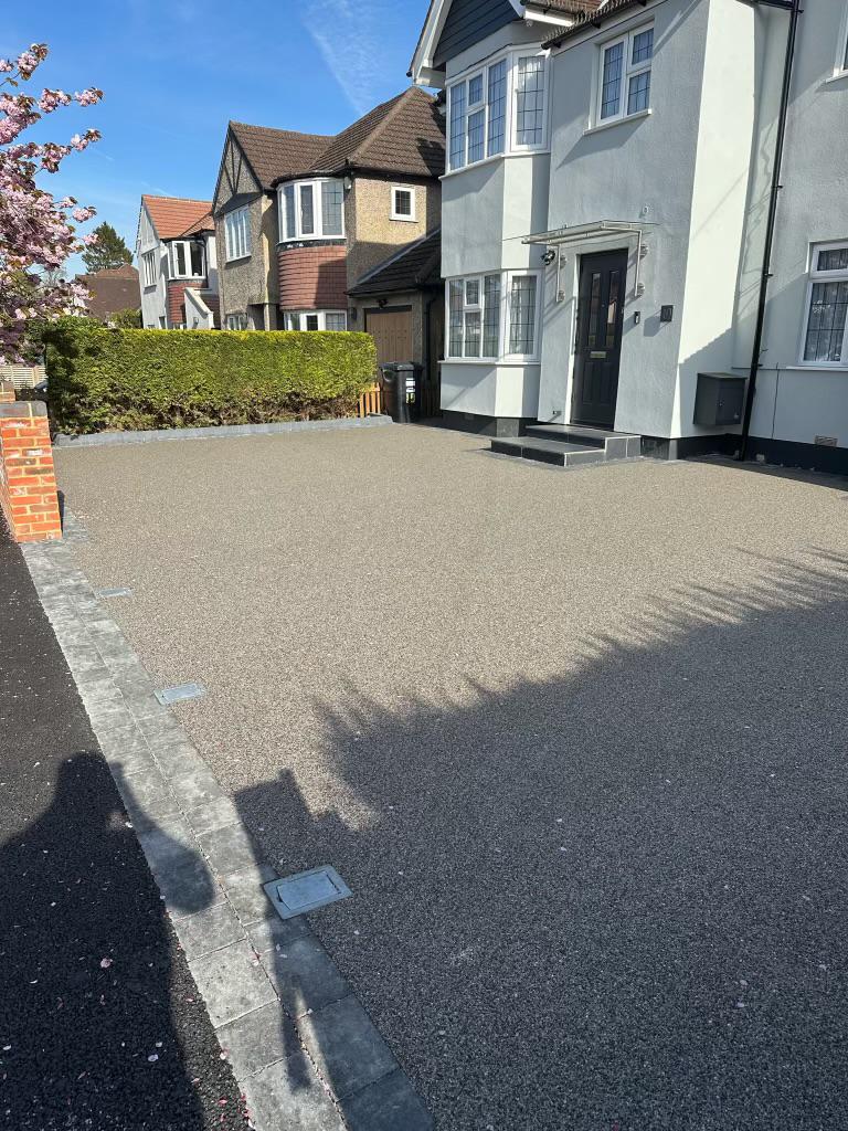 Resin-bound front drive with block-paved border outside a white semi-detached house