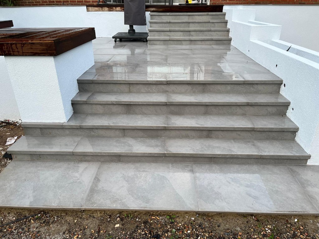 Modern stepped patio flight with large grey slabs and rendered flank walls